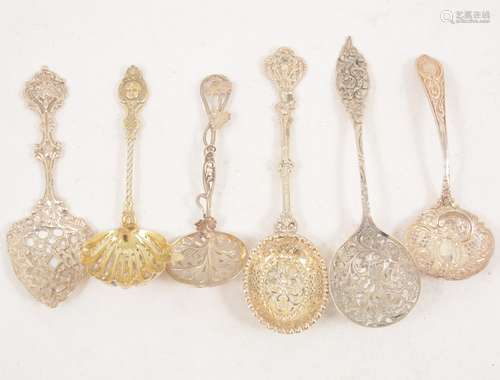 Six ornate silver and white metal sugar sifting spoons.