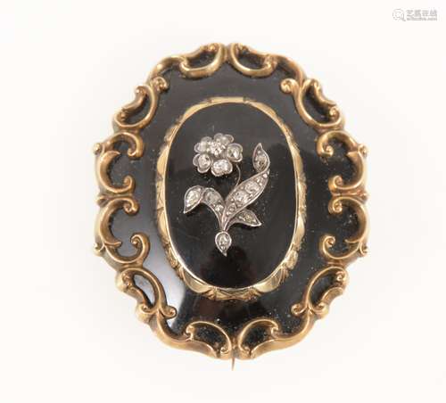 A Victorian mourning brooch set with a diamond flower motif, hair locket back.