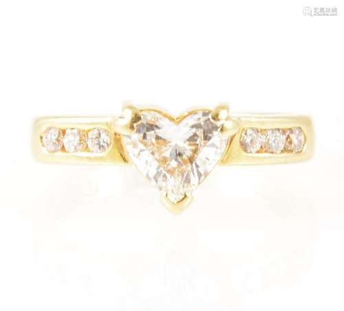 A heart shaped diamond ring with diamond shoulders.