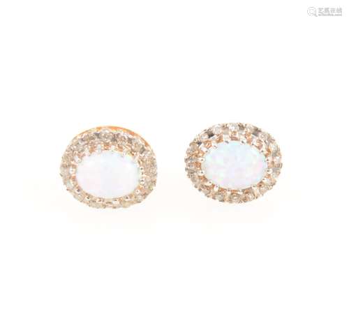 A pair of opal and diamond oval cluster earrings.