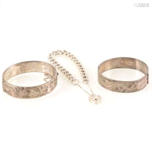 Two silver bangles and a silver curb link bracelet.