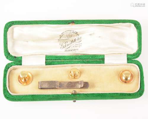 A cased set of three dress studs marked 18ct. and a silver tie slide.