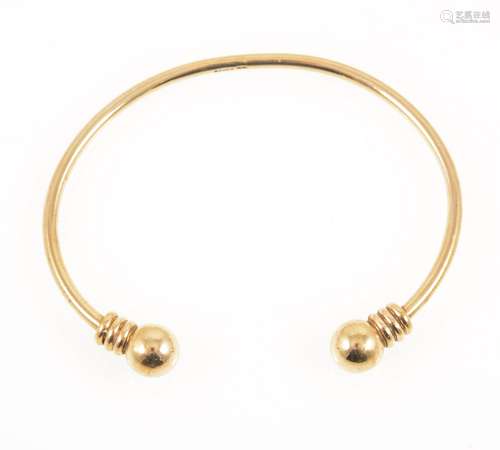 A 9 carat yellow gold torque style bangle with bead terminations.