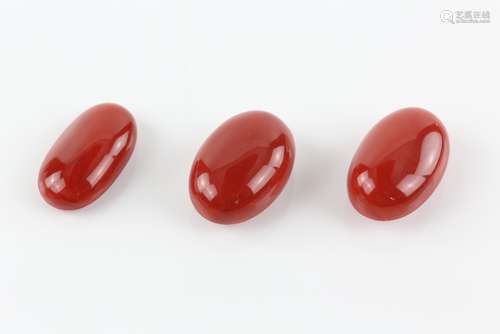 Three loose coral oval cabochons, largest measuring 36 x 23 x15 mm, another similar 35 x 23 x