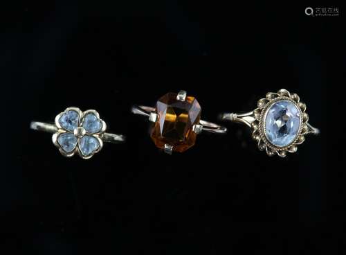 Three gem set rings, one set with an oval cut aquamarine, estimated weight 1.56 carats, size P,