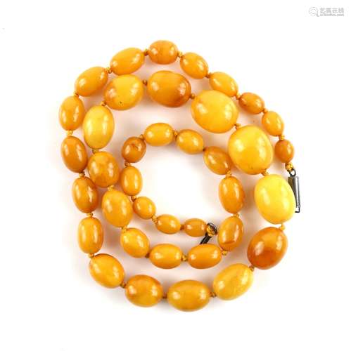 Amber necklace, elongated beads strung with knots to a silver tube clasp, length 60 cm.