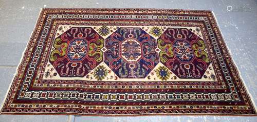 Persian Shirvan cream ground rug, with three medallions on a cream ground, within geometric borders,