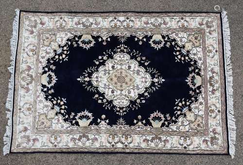 Persian style dark blue ground rug, central floral medallion on a dark blue ground with floral