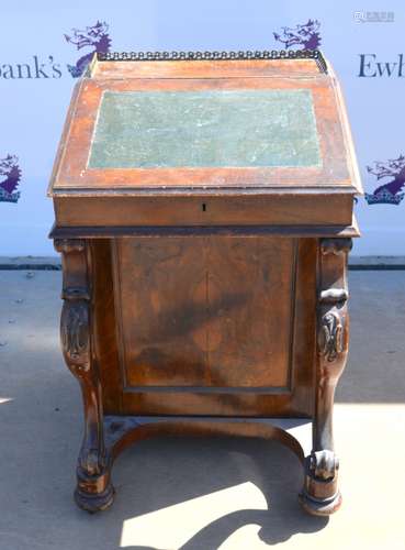 19th century walnut davenport with fitted interior and brass gallery rail, on scroll supports to bun