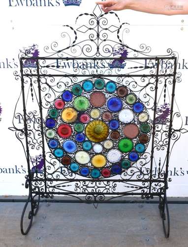 Early 20th century fire guard, with scrolling decoration and multi-coloured glass panels, on