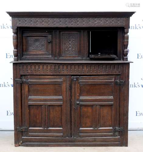 18th century carved oak buffet cupboard, with moulded cornice above floral carved frieze flanked