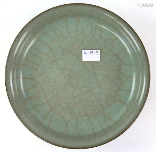 A Chinese circular dish with extensive inscription on the base; potted in the green/blue style of Ru