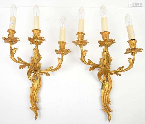 Pair of gilt metal three branch wall lights of foliate form, each 35 cm wide