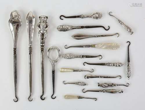 A collection of silver-handled button and glove hooks, including a teddy bear hook by Henry