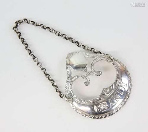 George III silver decanter label 'Brandy' of crescent and scroll form with engraved decoration,