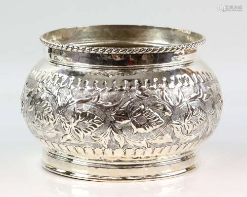 White metal bowl, the body decorated with scrolling flowers and leaves on a stippled ground, stamped