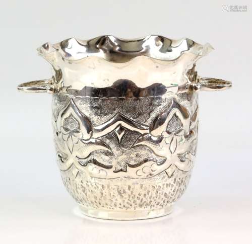 White metal wine bottle cooler, the body decorated with stylised flowers on a stippled background