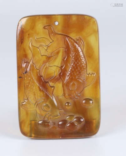 AN AMBER TABLET CARVED WITH AUSPICIOUS FISH PATTERN