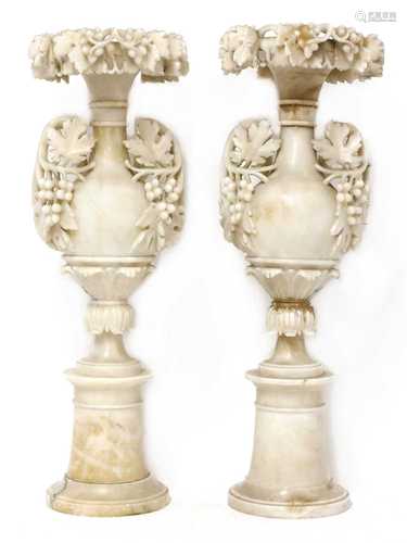 A pair of alabaster candle stands,