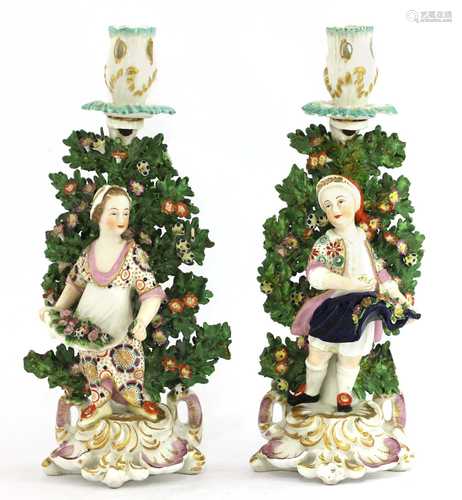 A pair of Continental porcelain figural candlesticks,