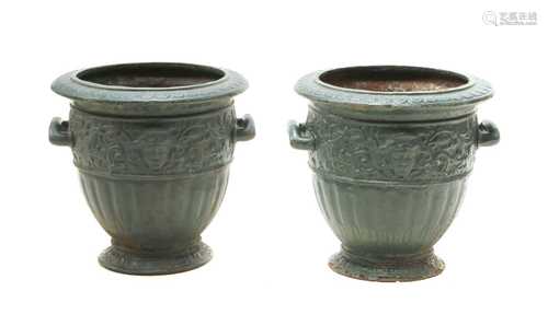 A pair of green painted cast iron urns,