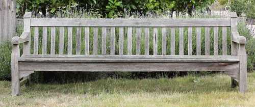 A large weathered teak garden seat,