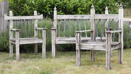 A weathered Gothic design teak garden bench,