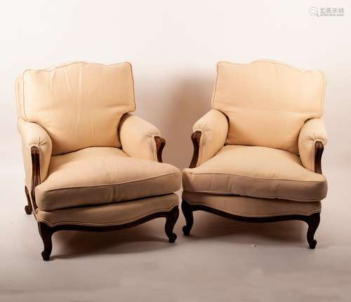 A pair of beech framed armchairs on carved legs with knurl feet