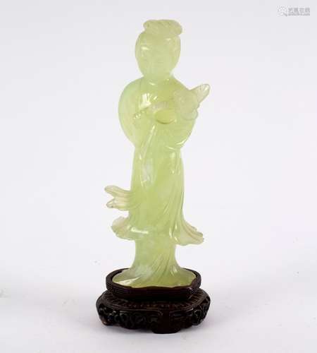 A 19th Century Chinese bowenite figure of Guanyin, standing holding a lotus blossom, 17.