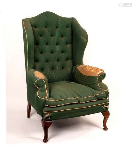 A Queen Anne style wing armchair on cabriole legs with pad feet,