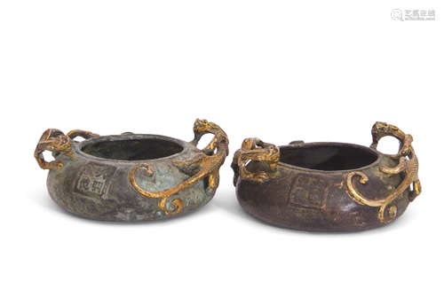 Two green metal Oriental small bowls both decorated in relief with dragon-like creatures in gilt