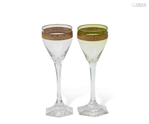 Pair of Continental wine glasses, one stained green, both glasses with a gilt foliate band to