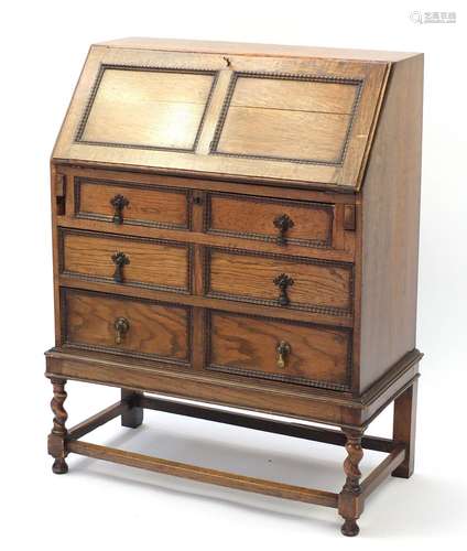 Oak bureau with a fall enclosing a fitted interior above three drawers, 101cm H x 76cm W x 38cm