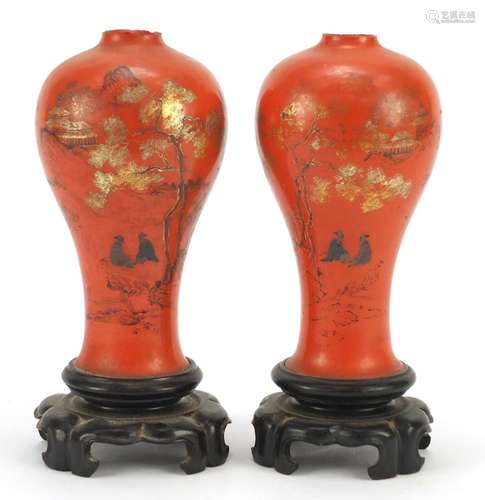 Pair of Chinese lacquered vases on stands, gilded and painted with figures and landscapes, each 21.