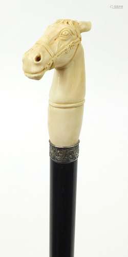 Good ebonised walking stick with carved ivory pommel in the form of a horse's head, having a