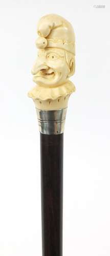 Good rosewood walking stick with carved ivory pommel in the form of Punch, having a sterling