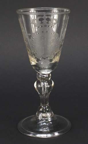 17th/18th century wine glass engraved with a coat of arms, having a baluster stem enclosing a tear