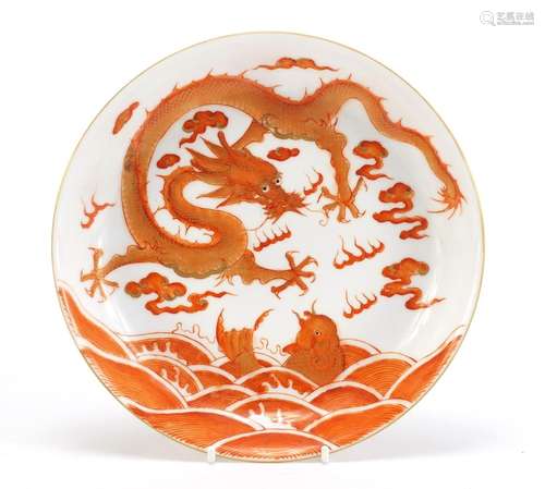 Chinese porcelain shallow dish hand painted in iron red with a dragon amongst clouds and fish in