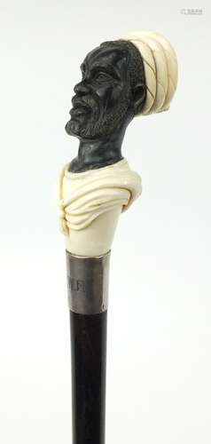 Good ebonised walking stick with carved ivory and horn pommel in the form of a blackamoor, having