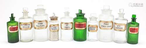 Antique glass apothecary jars with labels including three green examples, the largest 22cm high :