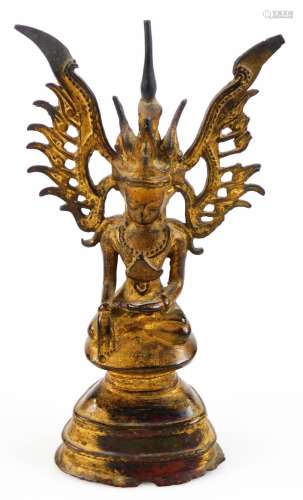 A metal figure of a Burmese Buddha wearing crown, with pierced wings, in seated pose, on an inverted
