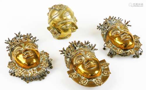 A 19thC Indian brass head of a Rajput woman, and three face mask wall decorations.