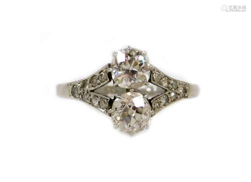 An Art Deco diamond ring, set with two old round cut stones of 8.5mm diameter each, split