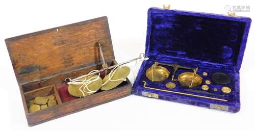 An early 19thC oak cased set of brass apothecary or gold weights and pan balance, and a further