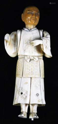 A 19thC Japanese bone okimino figure of a man, dressed in chased robe and having detachable head,