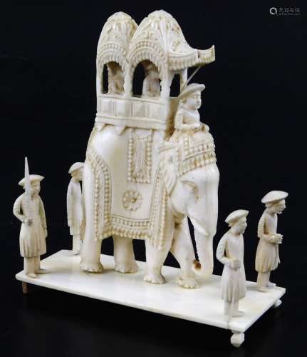 An early 20thC carved ivory figure group, of elephant with rider and carriage, set with two