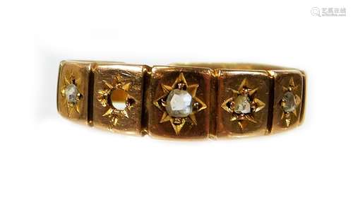 A diamond set dress ring, set with four tiny diamonds, (setting for five stones) on a yellow metal