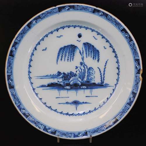 An 18thC tin glazed charger, decorated with an oriental garden scene in blue and white, 35cm