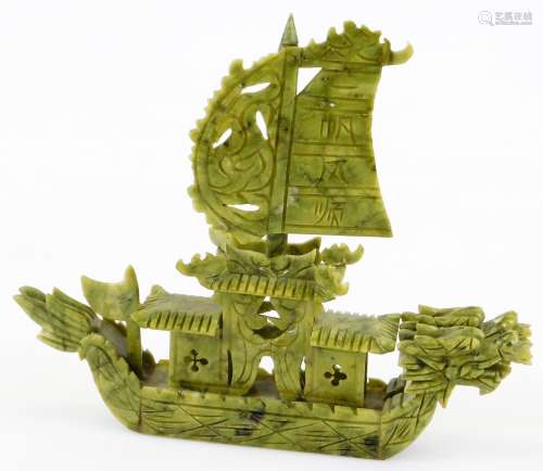 A 20thC Chinese stained green carved soapstone model of a boat, with shaped sail and dragons