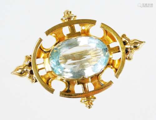 An early/mid 20thC aquamarine set brooch, with urn and crest design borders, in a yellow metal